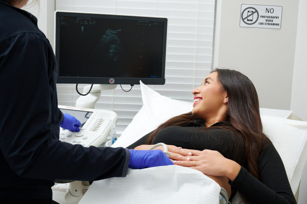 Patient viewing the ultrasound screen while doctor performs the scan.
