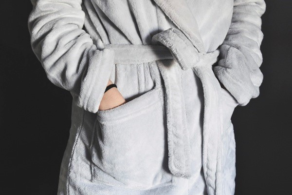 Woman wearing a light gray robe with hands in pockets, symbolizing comfort and privacy during cervical cancer screening at Hope Clinic for Women.