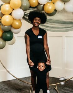 A mother and her young son smiling and interacting at the Hope Clinic for Women Baby Shower 2025 while receiving baby supplies and parenting resources.