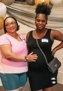 friends taking photos with the expecting mother while celebrating together at the Hope Clinic for Women Baby Shower 2025.