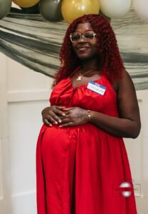Pregnant woman posing for photos, smiling and celebrating at the Hope Clinic for Women Baby Shower 2025.