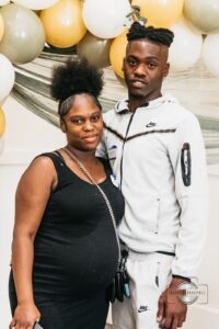 Pregnant woman and her partner posing for photos together, smiling and celebrating at the Hope Clinic for Women Baby Shower 2025.