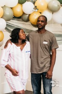 Pregnant woman and her partner posing for photos together, smiling and celebrating at the Hope Clinic for Women Baby Shower 2025.