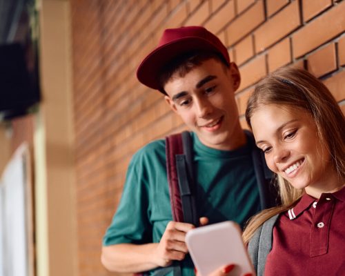 Couple standing outdoors, talking and smiling.